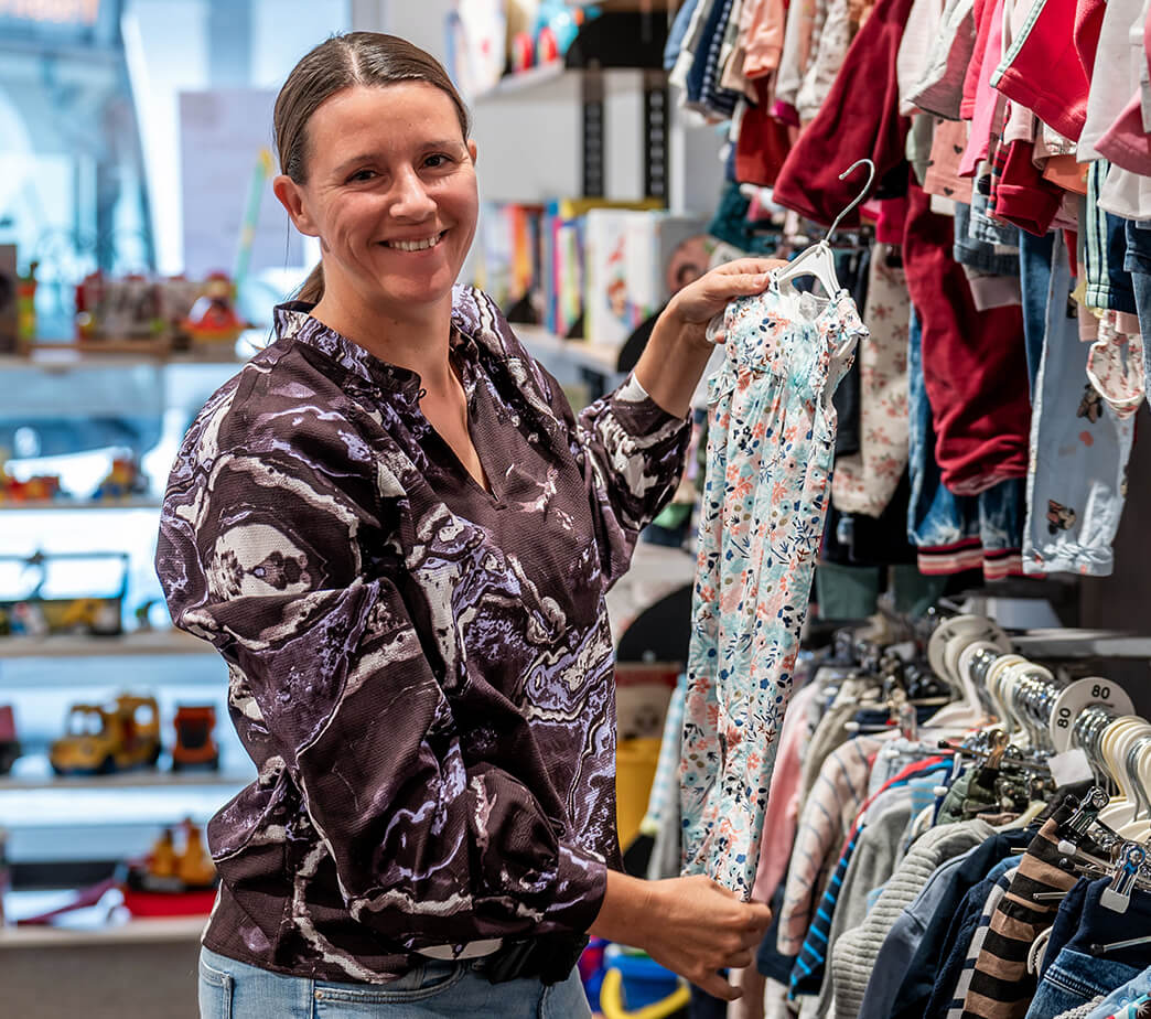 Sylvia Röth hält ein Kleidungsstück in der Hand, in ihrem Geschäft Klapperadatsch in Herzogenaurach