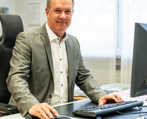 Armin Trippner von der Sparkasse Herzogenaurach, Sponsor der Initiative herzoBotschafter:innen hinter einem Schreibtisch sitzend