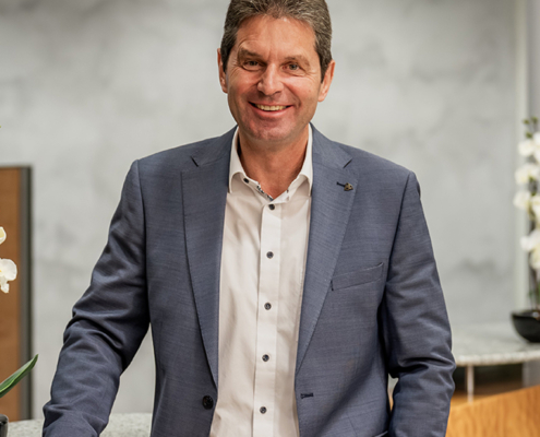 Roland Stopfer von der Sparkasse Herzogenaurach, Sponsor der Initiative herzoBotschafter:innen steht in der Sparkasse an einem Tresen