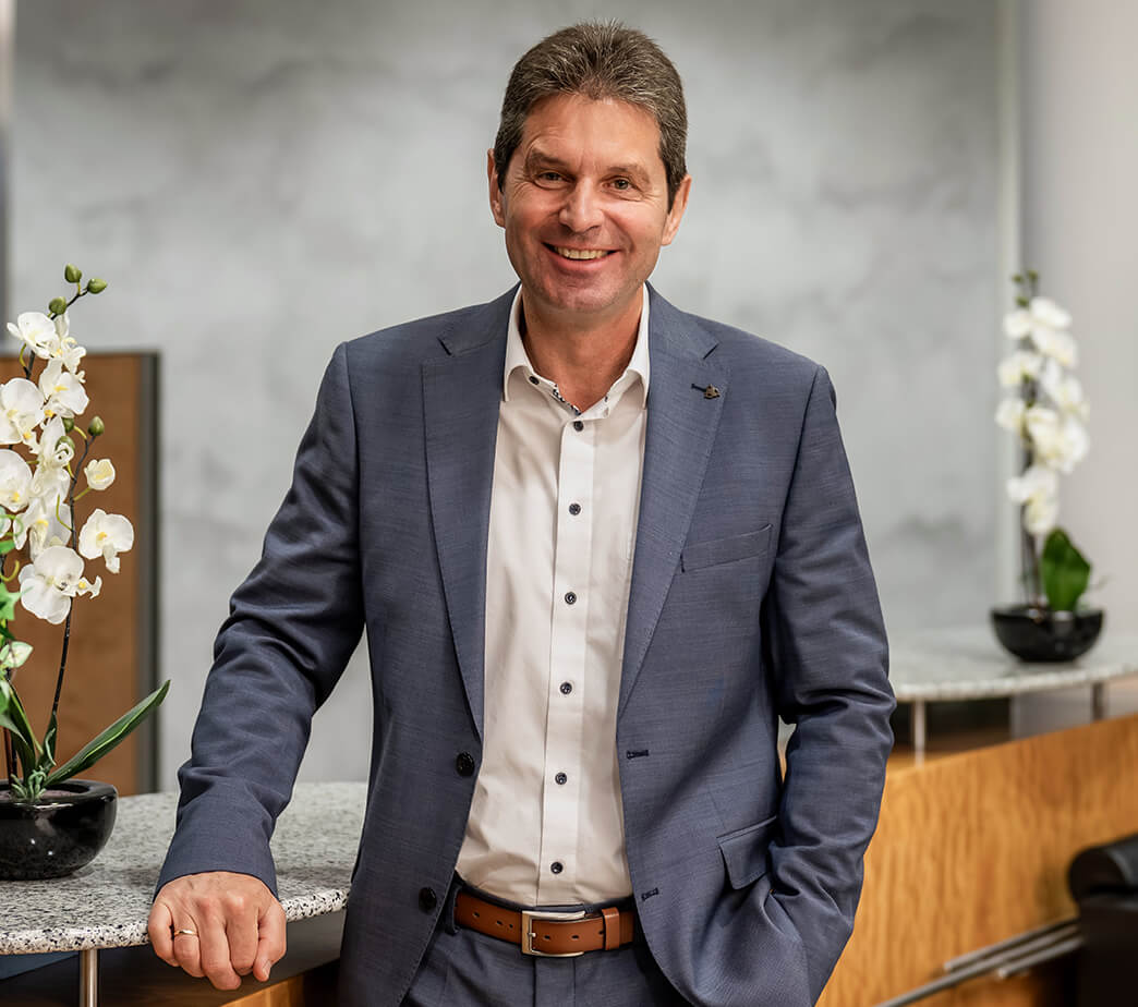 Roland Stopfer von der Sparkasse Herzogenaurach, Sponsor der Initiative herzoBotschafter:innen steht in der Sparkasse an einem Tresen